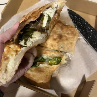 a hand holding a sandwich