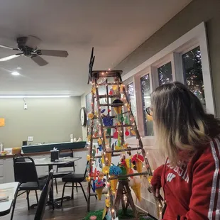 a woman decorating a christmas tree