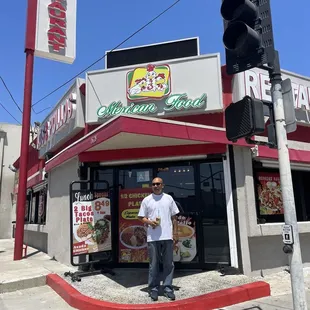 a man standing in front of a restaurant