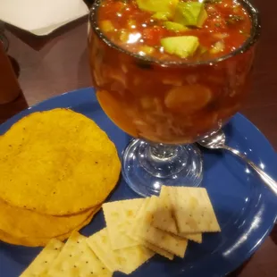 a bowl of salsa with tortillas and crackers