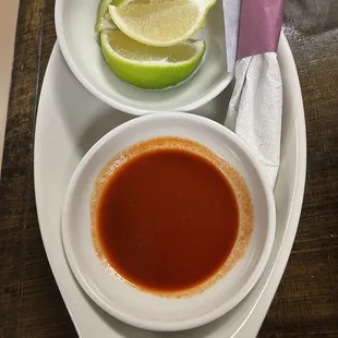 a bowl of sauce and a lime