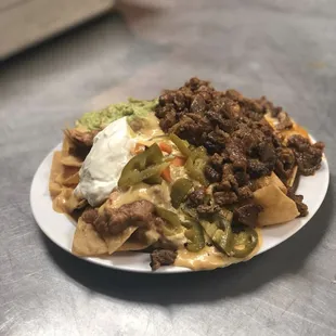 Super nachos beef or chicken served with beans, American cheese, guacamole &amp; sour cream!