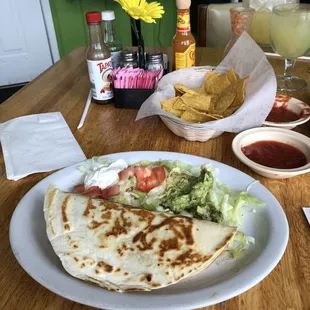 a plate of quesadillas, salsa, and chips
