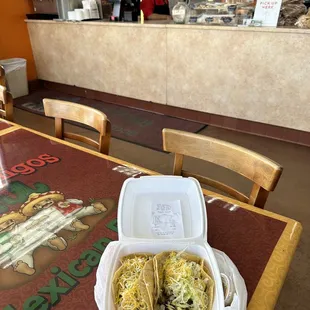 two tacos in a plastic container