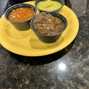 three bowls of condiments