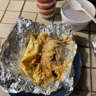 Migas taco with ranchero sauce, refried beans and cheese.