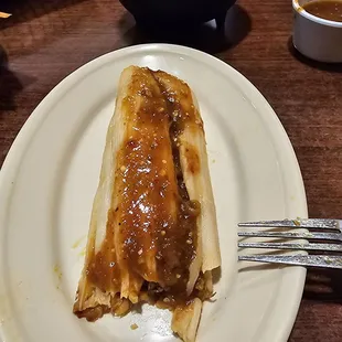 Tamale with red tomatillo sauce.