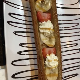 a banana split with whipped cream and strawberries