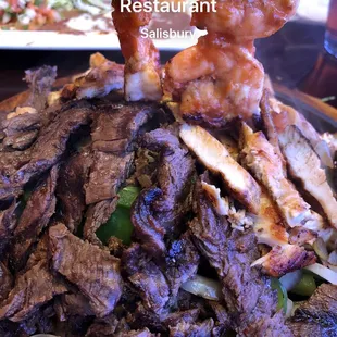 Parrilla for two, beef, chicken and shrimp on a delicious bed of grill onions and bell peppers.