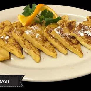 a plate of french toast with orange wedges