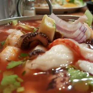 a bowl of seafood soup with a slice of lemon