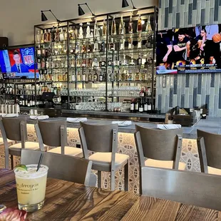 a bar with chairs and a television