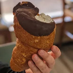 a person holding a pastry in their hand