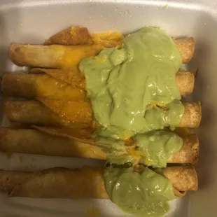 a container of cheese fries with guacamole