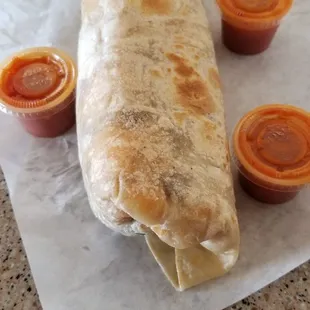 Breakfast burrito with hot sauce.