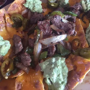 These nachos were tasty. Layered with beans and cheese. The guacamole was fresh and the steak was tender.
