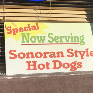 a special now serving sign in a store window