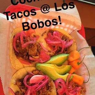 two tacoss with onions and avocado