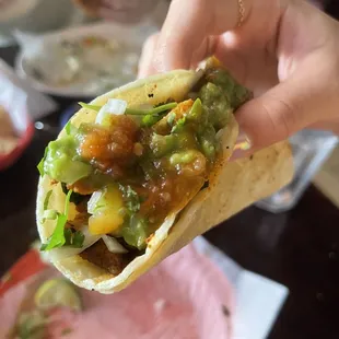 a hand holding a taco