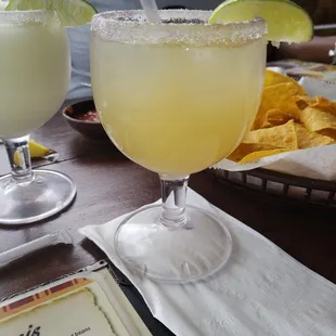two margaritas and chips on a table