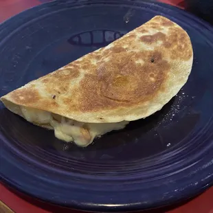 a blue plate with a quesadilla on it