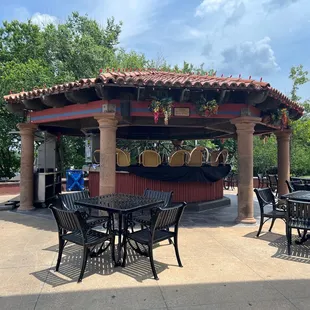 a patio area with tables and chairs