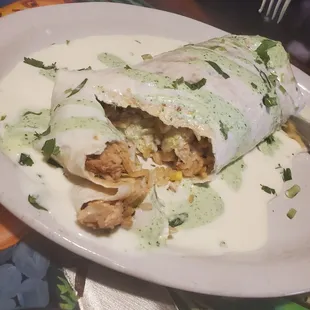 Cilantro burrito.Tender grilled chkn,Mexican rice w/veggies,black beans. Covered in cheese sauce and delish Cilantro sauce. Not spicy.