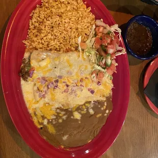 Beef and cheese enchiladas with rice and refried beans