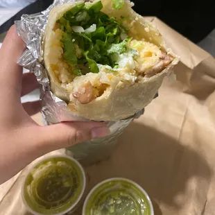 Carnitas super burrito ("Super" = + cheese, sour cream). Pinto beans, lettuce, cilantro, rice, onions, salsa, and your choice of meat.