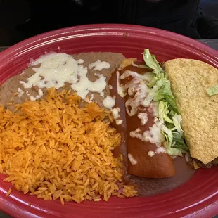 Taco and beef enchilada with rice and refried beans.