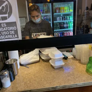 a woman wearing a face mask behind a counter
