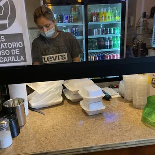 a man wearing a face mask behind a counter
