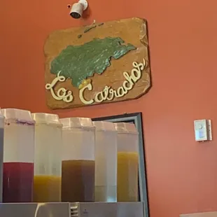 a sign above a row of juices