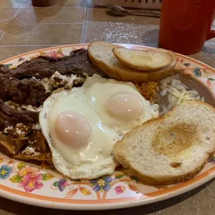No. 4 Chilaquiles with Arranchera, eggs over easy, rice, beans and toast.