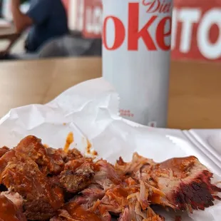 a plate of pulled pork and a can of coke