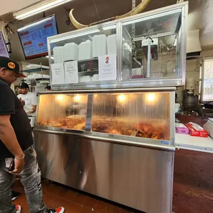 a man standing in front of a food counter