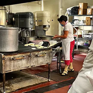 a woman preparing food in a commercial kitchen