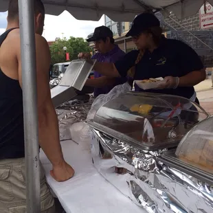a man serving hot dogs