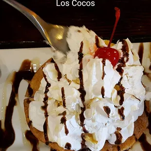 a desert with whipped cream and a cherry on top