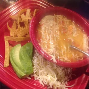 Chicken tour tills soup with chips cheese avocado