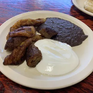 Fried plantains with sour cream and beans