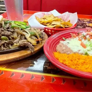Steak fajitas with Spanish rice, refried beans, sour cream, guacamole, pico and cheese
