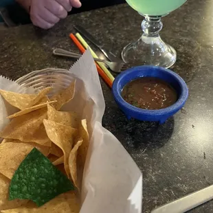 a bowl of chips and a drink