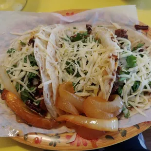 Trio of tacos on flour tortillas. So epic good.
