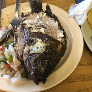 a plate of fish with a fork and knife
