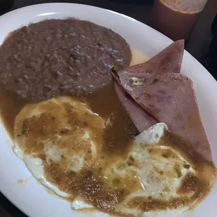 Today&apos;s Special:  &quot;Huevos Rancheros&quot; topped with green salsa, a side of refried beans and two pieces of fried ham!
