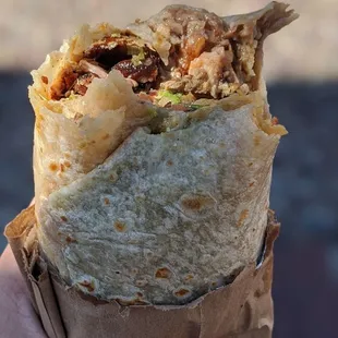 a hand holding a burrito