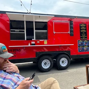 a man sitting in front of a food truck