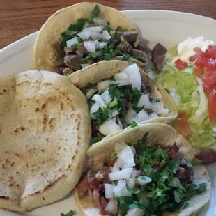 Dos checete tacos, un lengua, un papusa y menudo. Muy bueno