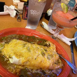 The Breakfast Burrito Grande (smothered) with a strawberry kiwi margarita in the back.